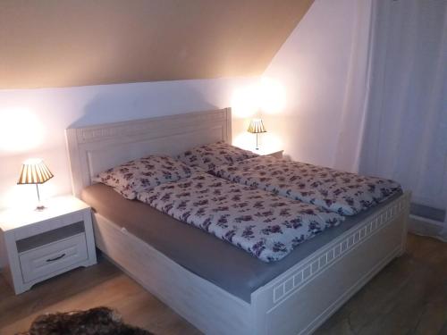 a bedroom with a bed with two lamps on it at Chata Remata 879 in Handlová