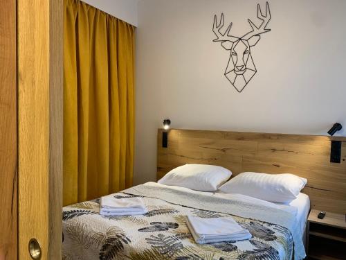 a bedroom with a bed with a deer head on the wall at Apartament Kalina - Wyszyńskiego in Świeradów-Zdrój