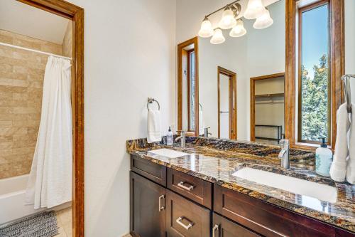a bathroom with two sinks and a large mirror at Woodland Park Chalet with Deck, Grill and Mtn Views! in Woodland Park