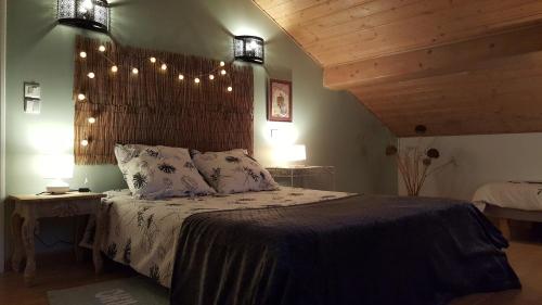 ein Schlafzimmer mit einem Bett mit Lampen an der Wand in der Unterkunft Le Pti Clos 
