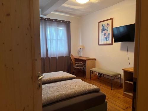 a hotel room with two beds and a desk at Hotel Weinstube am Markt in Gerolzhofen