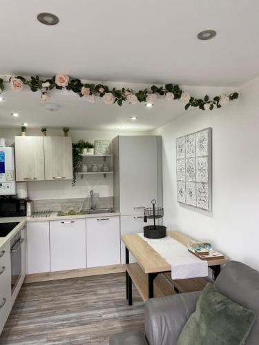 a kitchen with white cabinets and a wooden table at SNOWDON LODGE - GLAN GWNA HOLIDAY PARK CAERNARFON - Luxury Family Lodge in Caernarfon