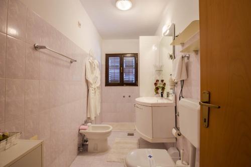 Baño blanco con aseo y lavamanos en Apartments Ragusa, en Rovinj