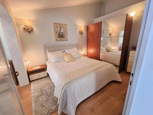 1 dormitorio con cama y espejo grande en Apartments Ragusa, en Rovinj