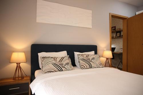 クルジュ・ナポカにあるCity Apartment Dorobantilorのベッドルーム1室(白いベッド1台、ランプ2つ付)