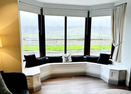 a cat sitting on a couch in front of a window at Island Elegance - Wild Atlantic Way in Portmagee
