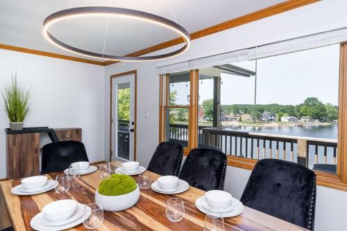 a dining room with a table and chairs and a large window at 5BR Lakefront Getaway with hot tub in Cadillac