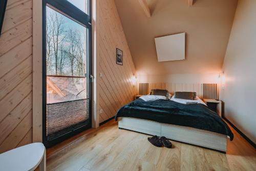um quarto com uma cama e uma grande janela em Domek Siodemka em Zakopane
