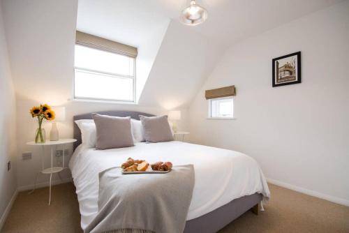 a bedroom with a bed with a tray with teddy bears on it at Modern Apartment in the Heart of Oxford with Secure Underground Parking in Oxford