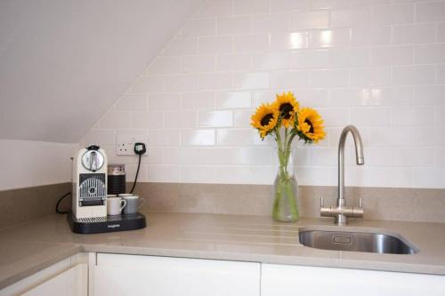 a vase of sunflowers sitting on a kitchen counter at Modern Apartment in the Heart of Oxford with Secure Underground Parking in Oxford