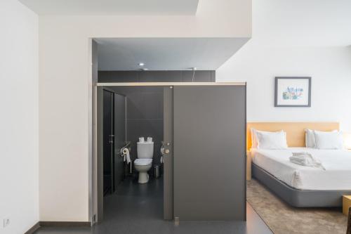 a bedroom with a bed and a bathroom with a toilet at Boticas Hotel Art & SPA in Boticas