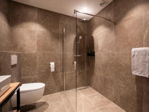 a bathroom with a shower with a toilet and a sink at Parade Elluf in Venlo