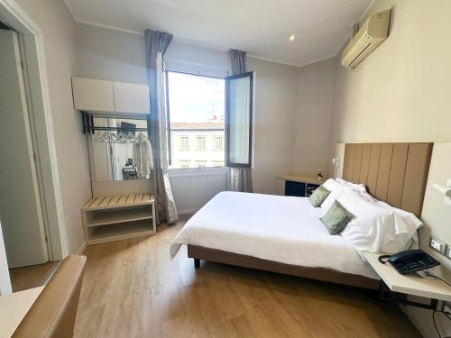 um quarto com uma cama, uma secretária e uma janela em Hotel Giappone em Florença