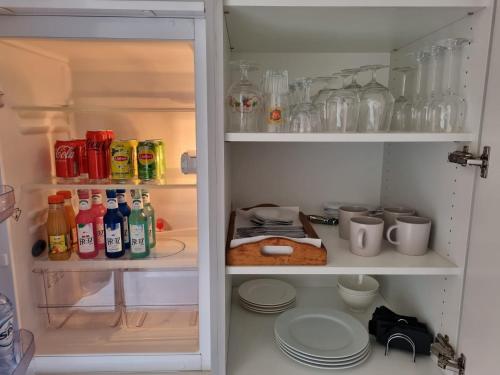 a refrigerator filled with lots of drinks and dishes at Business accommodation Plus Garden Terrace in Geel