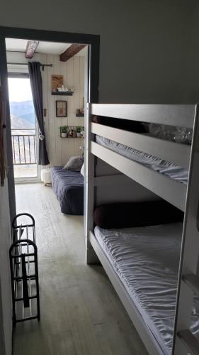 a bedroom with a bunk bed and a balcony at VUE PANORAMIQUE SUR LES PYRÉNÉES in Saint-Lary-Soulan