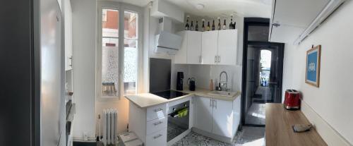 una cocina con armarios blancos y fregadero en Chalet basque 6 couchages centre ville Biarritz en Biarritz