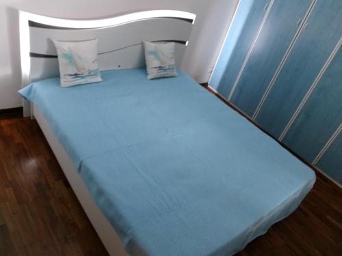 - un petit lit avec des draps et des oreillers bleus dans l'établissement Residance Park, à Grignano