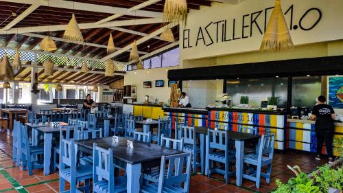 a restaurant with blue chairs and tables and a counter at Hotel Margarita Village in Porlamar