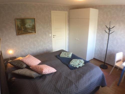 una camera da letto con un letto con cuscini sopra di Dubbelrum med extrasäng på markplan i lugnt villaområde a Malmö