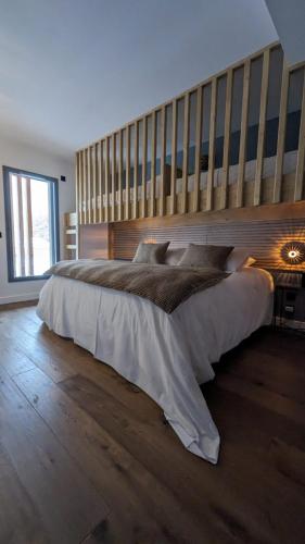 a bedroom with a large bed with a wooden headboard at Chalet Coste Belle in La Fare-en-Champsaur