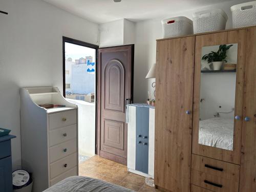 Un dormitorio con un gran armario de madera y una cama en La Buganvilla rooms, en Arrecife