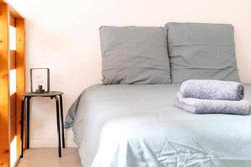 un lit avec deux oreillers dessus dans l'établissement Charmant Duplex Quartier La Pironnière aux Sables dOlonne - 6 pers, à Les Sables-dʼOlonne