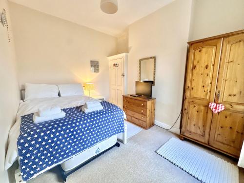 a bedroom with a bed and a dresser and a mirror at Nunmill Nest By Bishy Road With Free Parking in York