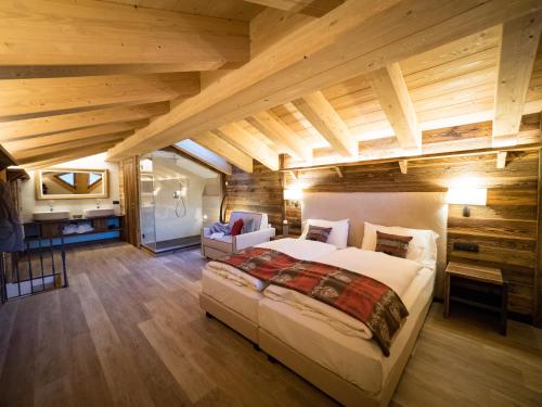 um quarto com uma cama grande num quarto com tectos em madeira em Chalet Dolce Vita em Livigno