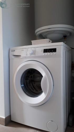 a white washing machine sitting in a room at Calme et Central à Jonzac in Jonzac