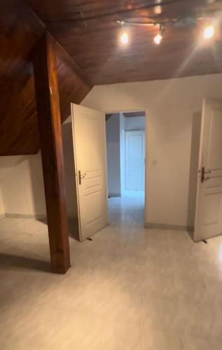 una stanza vuota con due porte bianche e un corridoio di Maison entière équipée 220m2 a Clamart
