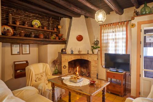 sala de estar con chimenea y mesa en Zarzo del Tragaluz, en Fuenteheridos