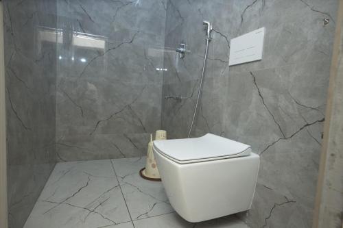 a bathroom with a white toilet and a shower at Zingle Stay Airport Hotel in Chennai