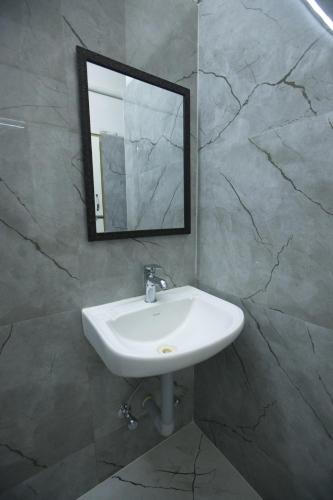 a bathroom with a sink and a mirror at Zingle Stay Airport Hotel in Chennai