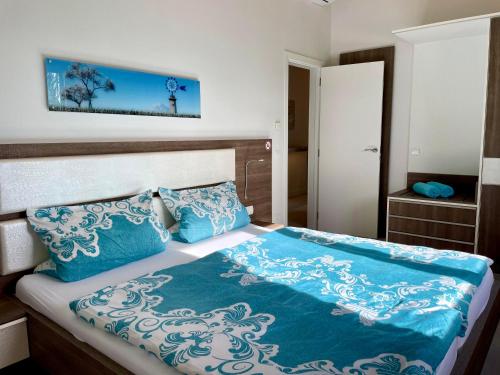 a bed with blue and white sheets and pillows at Villa Sun Club home in Llucmajor