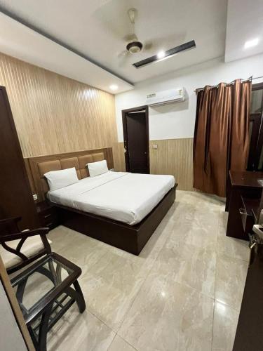 a bedroom with a bed and a chair in it at Hotel Landmark in Sahāranpur