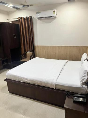 a bedroom with a bed and a desk and a bed sidx sidx sidx at Hotel Landmark in Sahāranpur