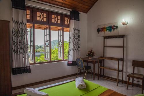 a bedroom with a green bed and a window at Antique Tourist Lodge in Kandy