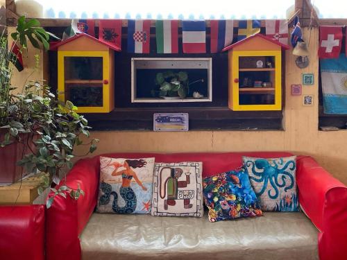 a living room with a red couch and a play house at Hostal Kuyen in Pichilemu