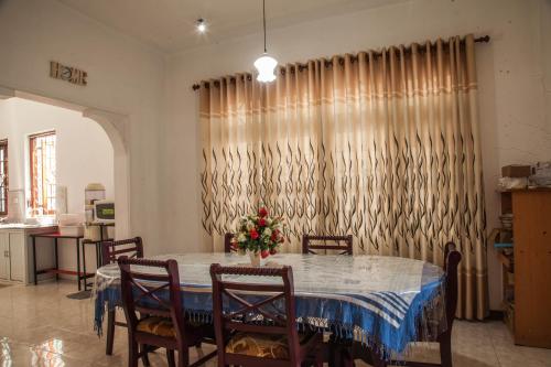 a dining room with a table and chairs and a curtain at Antique Tourist Lodge in Kandy