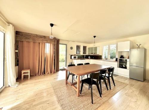 une cuisine et une salle à manger avec une table et des chaises dans l'établissement Agréable maison au cœur du parc régional du Perche, à Longny-au-Perche