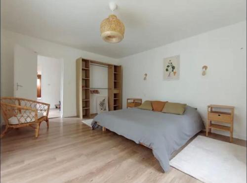 une chambre avec un grand lit dans une pièce dans l'établissement Agréable maison au cœur du parc régional du Perche, à Longny-au-Perche