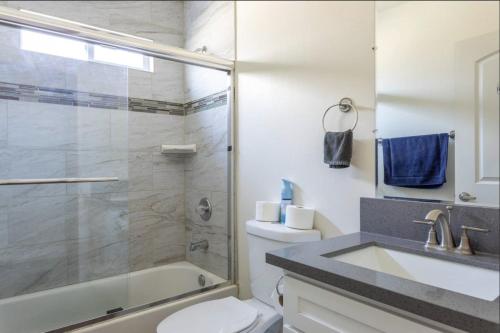 a bathroom with a shower and a toilet and a sink at 5 BR Home Near USC - Perfect Location in Los Angeles