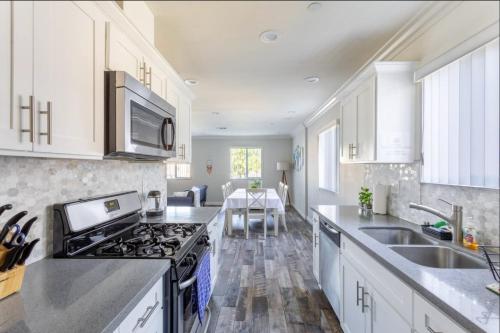 a kitchen with white cabinets and a stove top oven at 5 BR Home Near USC - Perfect Location in Los Angeles