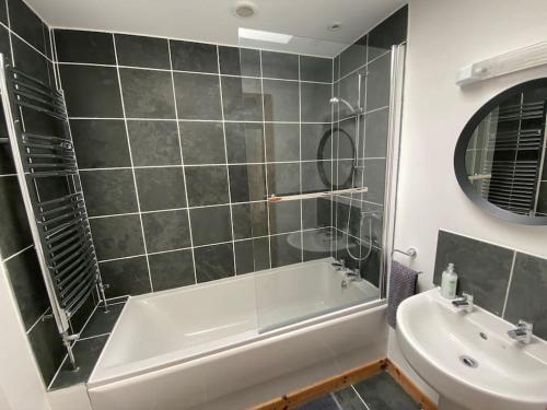 a bathroom with a tub and a sink at St Benedicts Street Flat with Roof Terrace in Norwich