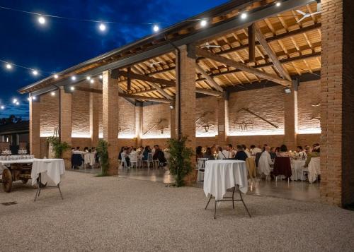 eine Gruppe von Menschen, die in einem Pavillon an Tischen sitzen in der Unterkunft Agriturismo San Giuseppe in Gattatico