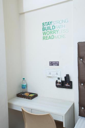 a desk in a room with a sign on the wall at Zingle Stay Airport Hotel in Chennai