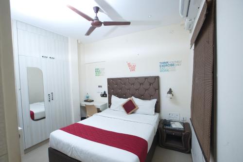 a bedroom with a bed and a ceiling fan at Zingle Stay Airport Hotel in Chennai