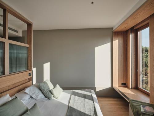 a bedroom with a bed and a large window at Qgat Restaurant Events & Hotel in Sant Cugat del Vallès