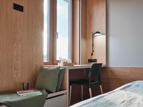 a bedroom with a desk and a chair and a bed at Qgat Restaurant Events & Hotel in Sant Cugat del Vallès