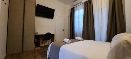 um quarto de hotel com uma cama branca e uma janela em R & A Minerva Suites em Pavia